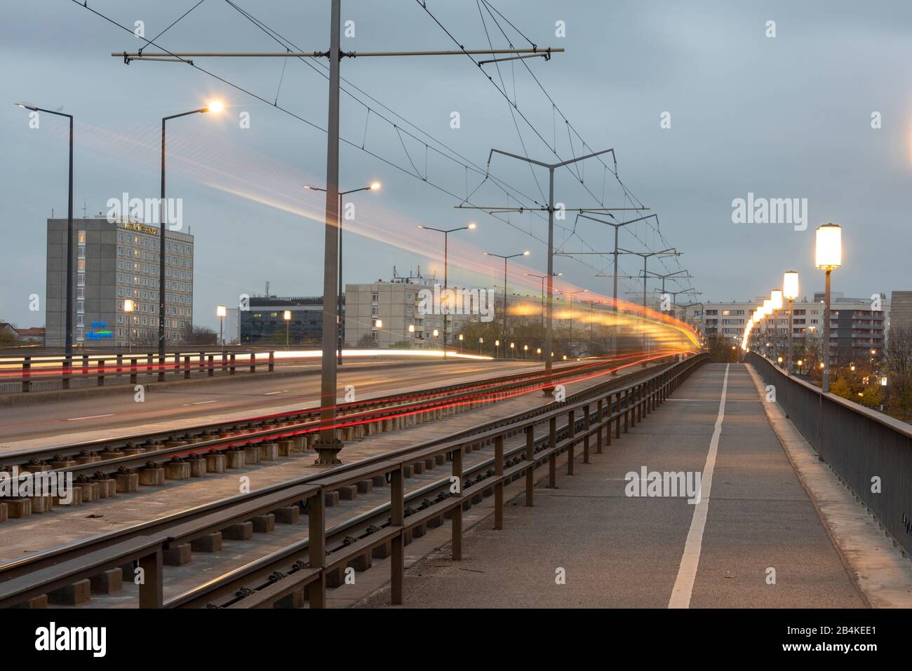 Deutschland, Sachsen. Dresden, beleuchtete Carolabrücke, Wolkenkratzer, Lichtwege einer Straßenbahn. Stockfoto