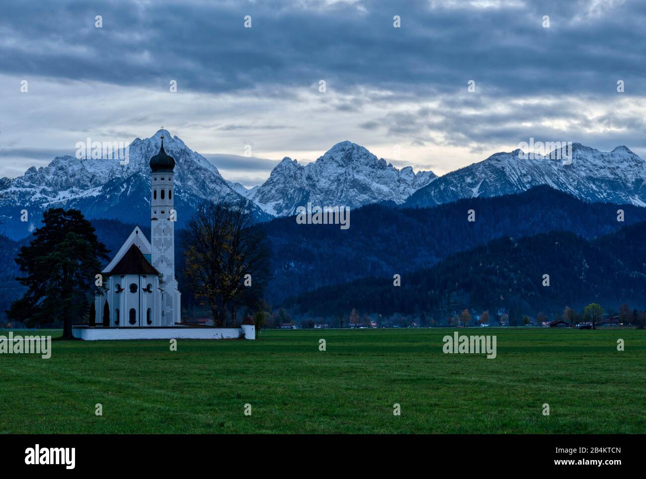 Deutschland, Bayern, St. Coloman mit Allgäuer Bergen bei Hohenschwangau im Abendlicht Stockfoto