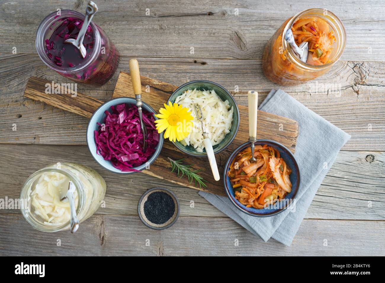 Weißkohl, Kimchi und Rotkohl gegoren, in konservierenden Gläsern eingepickt, in kleinen Schüsseln serviert Stockfoto