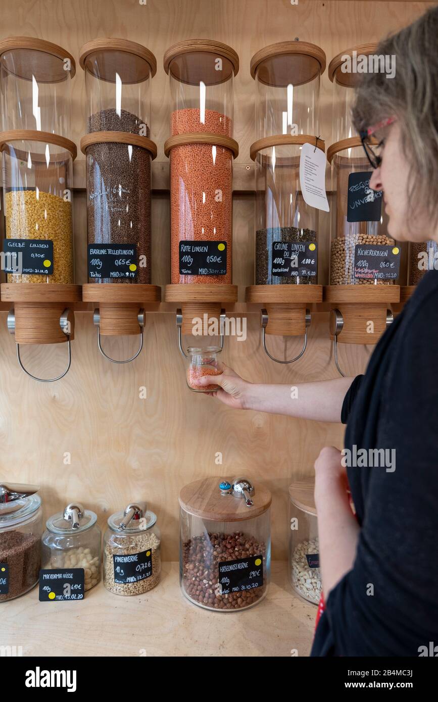 Die Inhaberin eines Unverpacktladens tritt mit einem Abfüllungsregister für Getreide an. Stockfoto