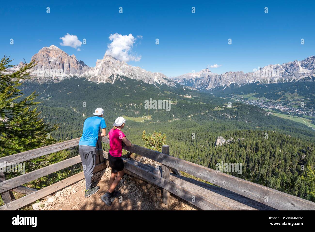 Cortina d'Ampezzo, Provinz Belluno, Venetien, Italien, Europa. Kinder haben das Bergpanorama mit den Tofanegippeln und der Stadt Cortina d'Ampezzo hinter sich Stockfoto