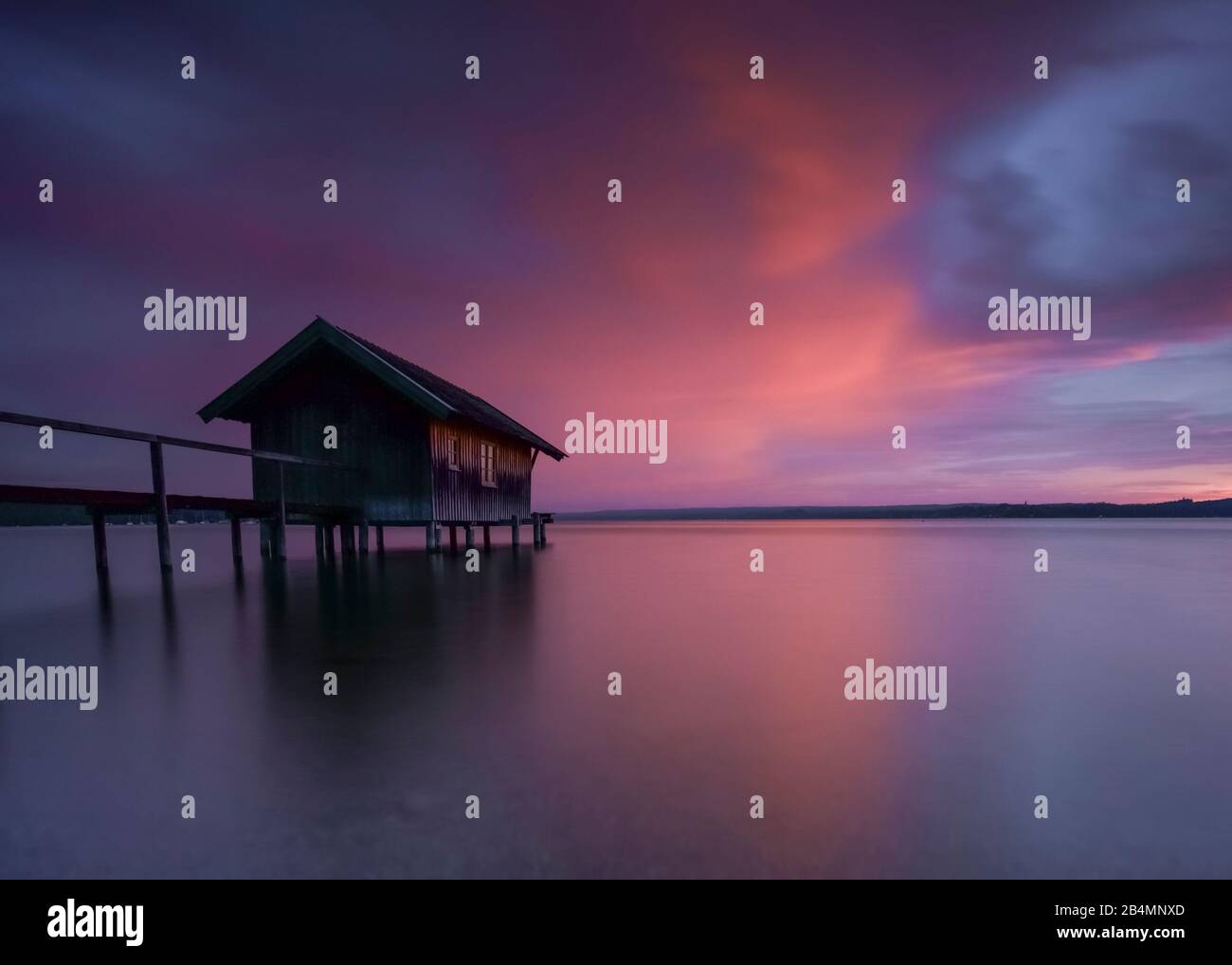 Sommer in Bayern. Impressionen aus dem Alpenvorland: Bootshaus am Ammersee bei Sonnenuntergang, lange Exposition. Stockfoto