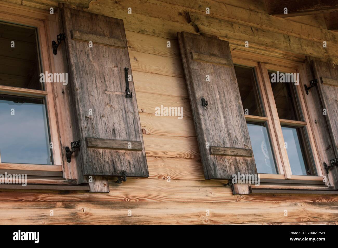 Sommer in Bayern. Eindrücke aus dem Alpenvorland: Bergwanderung auf der Hörnle. Holzfenster einer Almhütte. Stockfoto