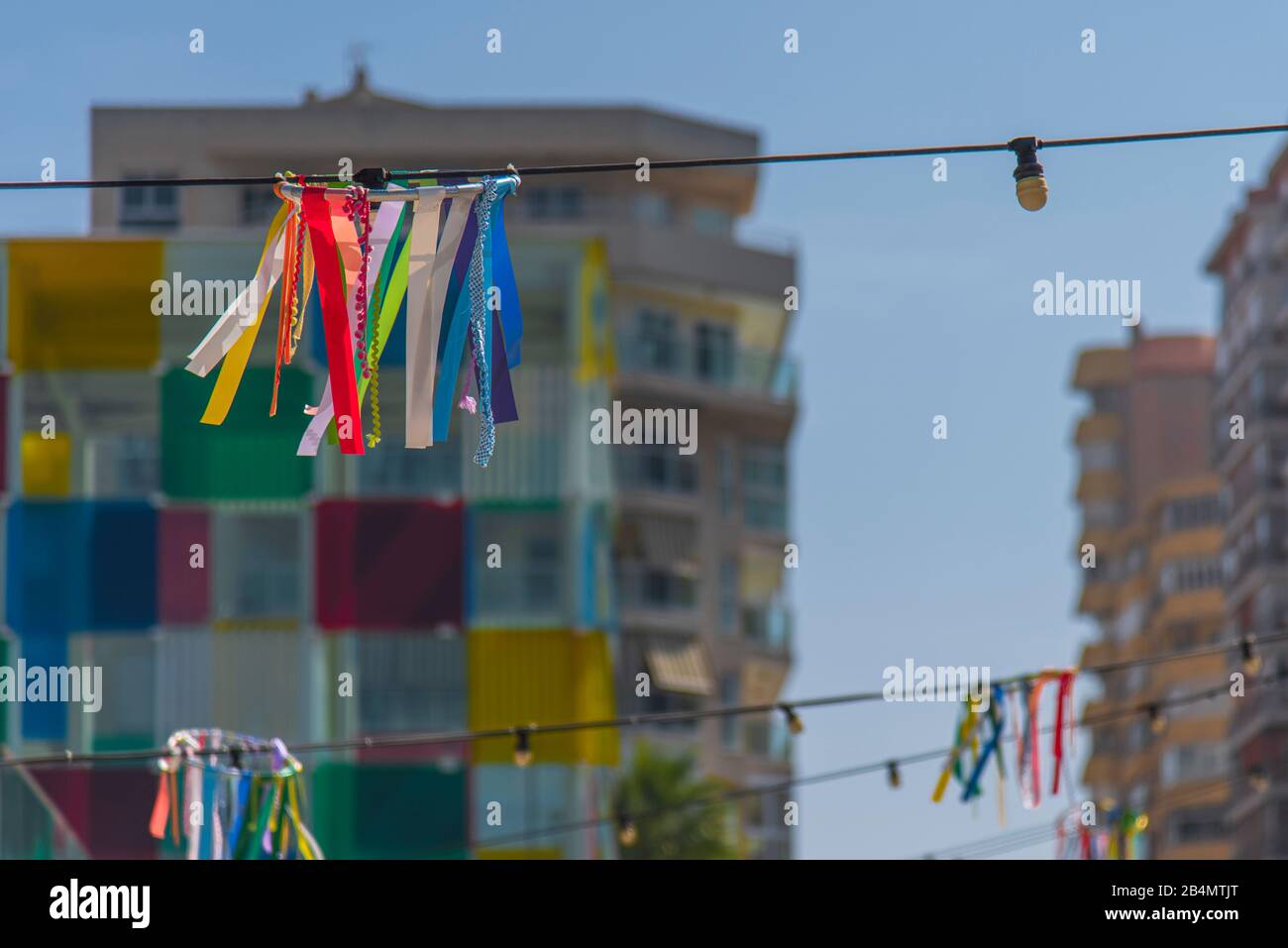 Eines Tages in Málaga; Impressionen aus dieser Stadt in Andalusien, Spanien. Centre Pompidou Málaga in 'El Cubo', im Vordergrund dekorierte Straßenbeleuchtung Stockfoto