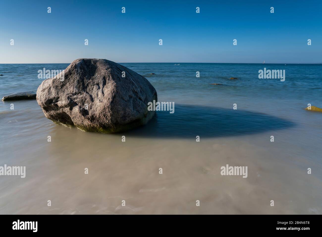 Ostsee am Abend Licht, lange Belichtung, Strand mit Steinen, die vom Wasser gewaschen werden, Sonne und bewegtes Meer am Strand Stockfoto