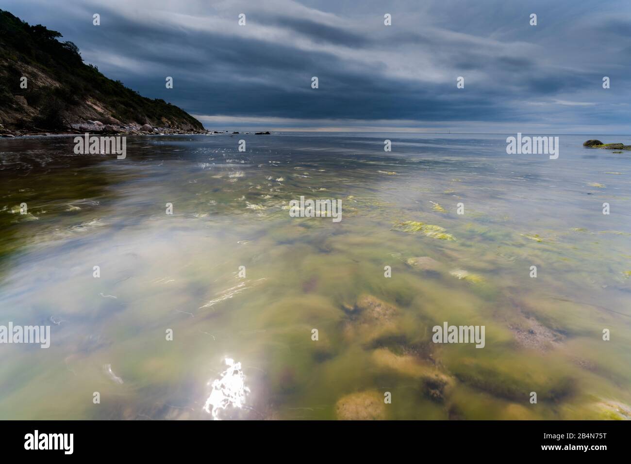 Ostsee am Abend Licht, lange Belichtung, Strand mit Steinen und Algen, die vom Wasser gewaschen werden, Stockfoto