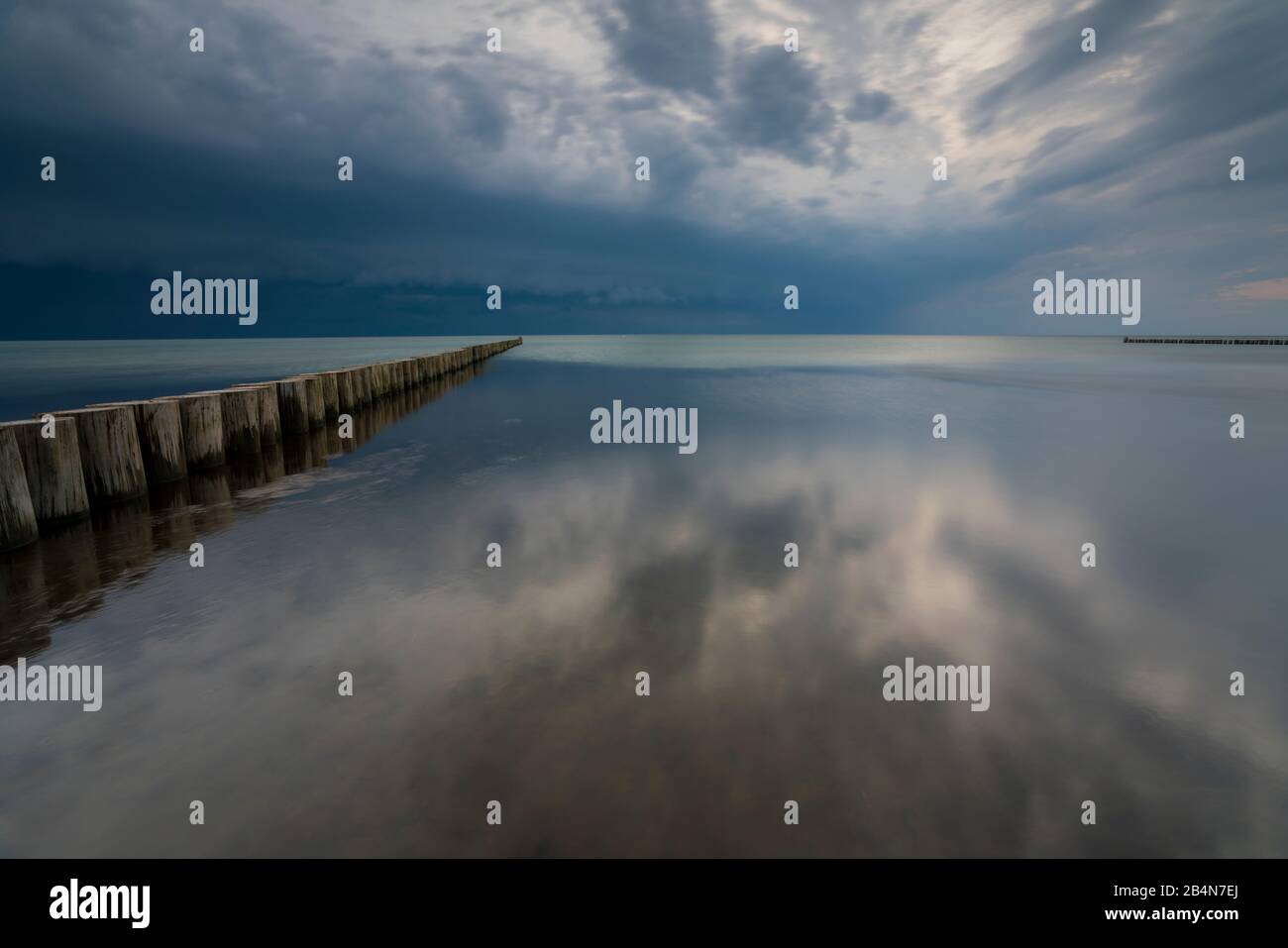 Ostsee im Abendlicht, lange Belichtung, untergehende Sonne, dunkle Wolken, ein Tiefdruckgebiet ist unterwegs Stockfoto