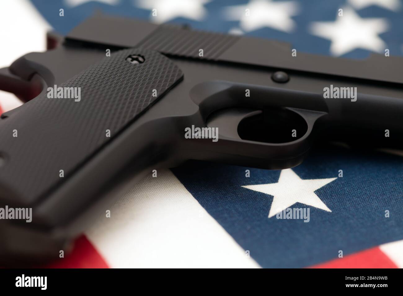 Halbautomatische Pistole auf amerikanischer Flagge. Konzept der amerikanischen Waffenkultur, die zweite Änderung und das Recht, Waffen in den USA zu tragen. Stockfoto