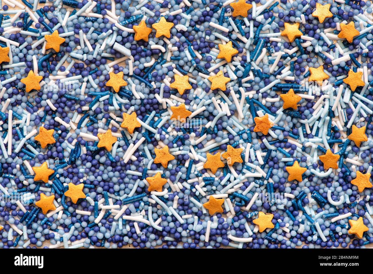 Kuchendekorationen. Blaue Gesprenge, Zuckerkugeln, Vermicelli-Zuckerstränge und Karamellsterne Stockfoto