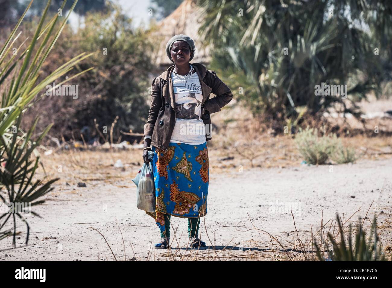 Kapako, Kavango West, Namibia - 29. Juli 2019: Lokale schwarze Frau Mit Plastikbags und Wasserbehälter Stockfoto