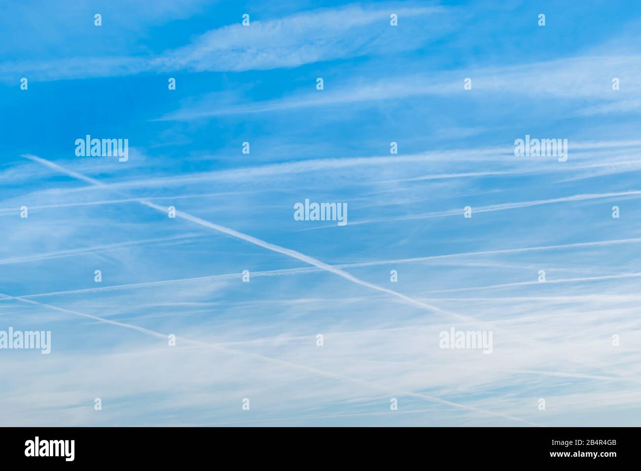 Blauer Himmel und Wolken mit Spuren von Flugzeughintergründen. Stockfoto