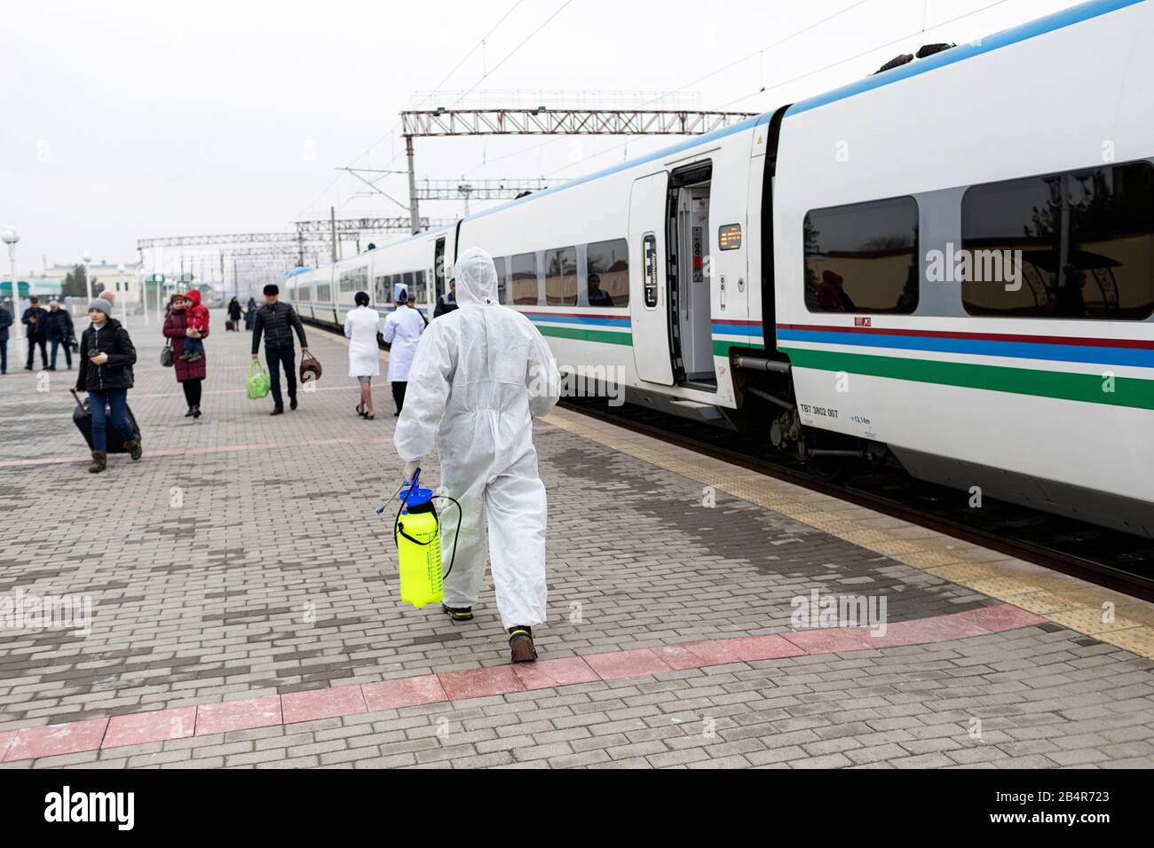 Arbeiter in weißen Schutzanzügen desinfizieren Coronavirus auf der Schnellfahrstrecke Samarkand - Buchara, februar 2020, Usbekist Stockfoto