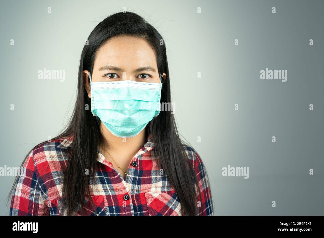 Seitenansicht der Frau in Maske wegen Luftverschmutzung und Epidemie in der Stadt. Schutz vor Viren, Infektionen, Abgasen und industriellen Emissionen Stockfoto
