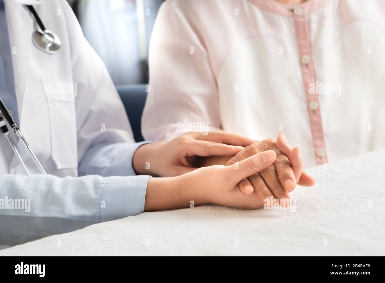 Der Arzt hält den Patienten der Seniorin zusammen Stockfoto