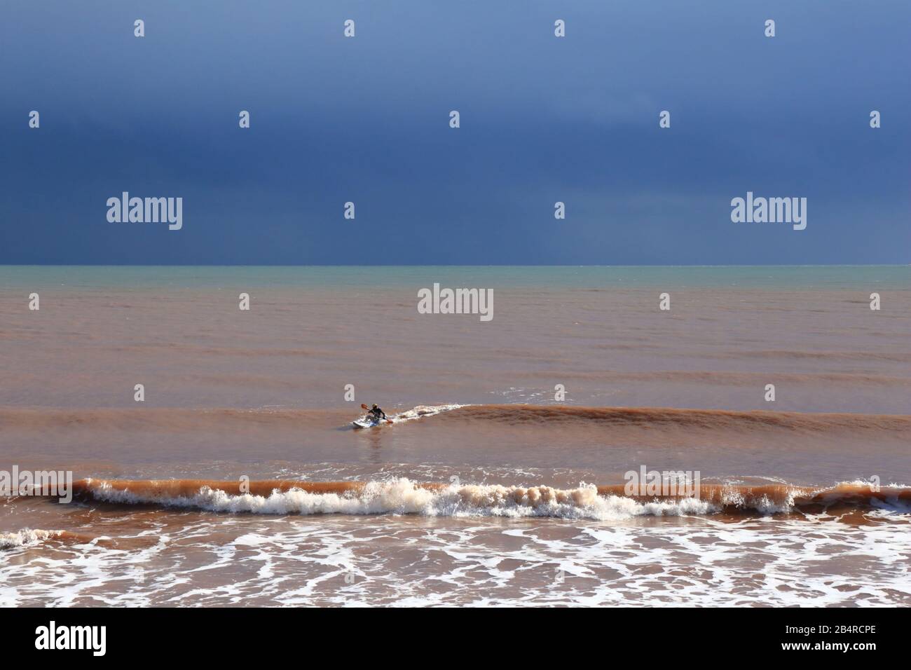 Kajaker in Wetsuit genießen Fahrt an einem kalten regnerischen Tag in Devon. Stockfoto