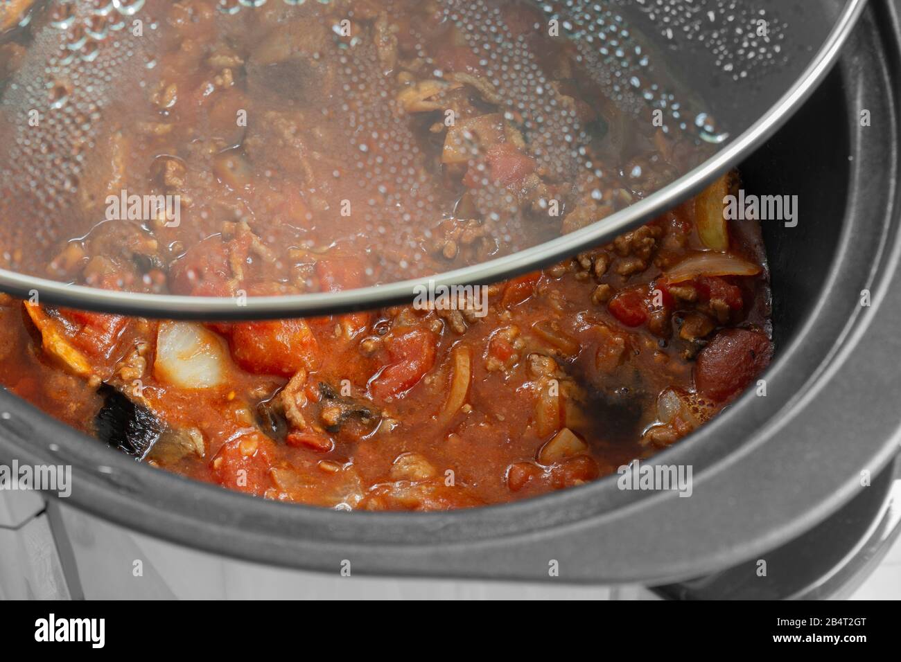Bolognese Sauce Kochen in einem langsamen Herd mit Glasdeckel abgehoben. Selektive Farbe Stockfoto