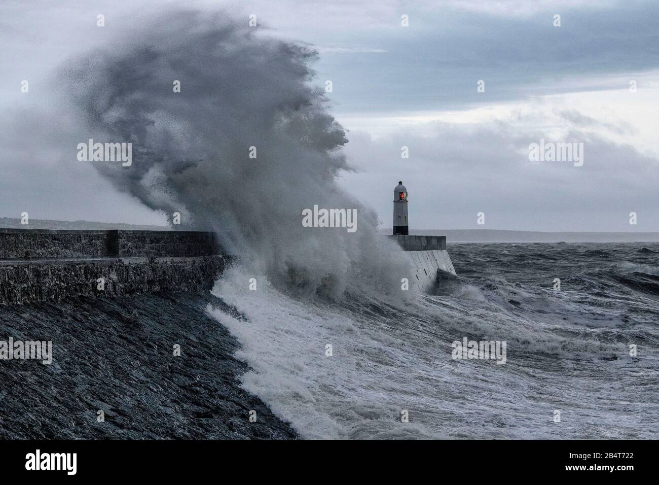 09.02.20. STURM CIARA. Wellen stürzen über das Wellenbrecher und den Leuchtturm in Porthcawl in Südwales, als Storm Ciara das Vereinigte Königreich trifft. Stockfoto