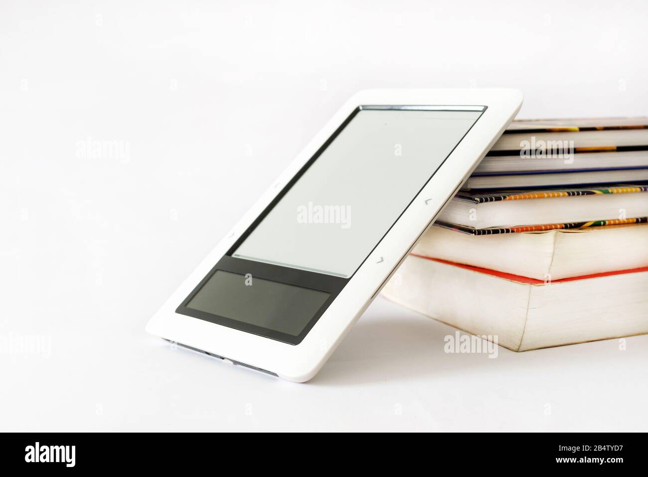 E-Book-Leser in pinkfarbenem Fall auf einem Haufen alter Bücher Stockfoto