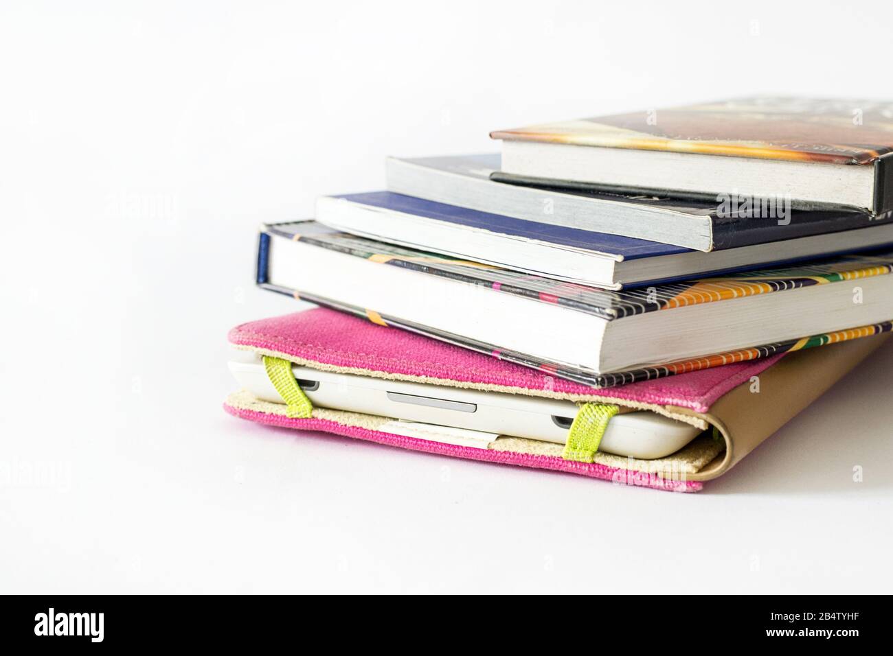 E-Book-Reader in pinkfarbener Hülle mit einigen alten Büchern Stockfoto