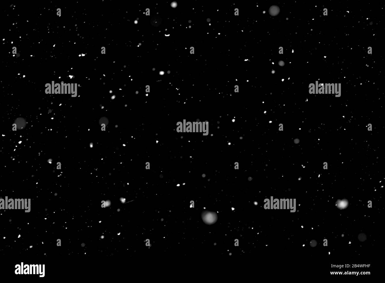 Leichter Schneefall in kurzer Belichtungszeit vor schwarzem Hintergrund. Funktioniert auch als Overlay. Stockfoto