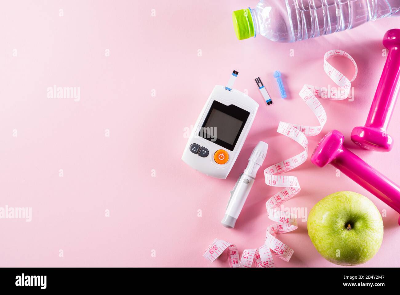 Gesundes Lifestyle-, Lebensmittel- und Sportkonzept. Draufsicht des Diabetes-Testers mit Sportgerät Messband pink Hanteln, Sportwasserflaschen, Stockfoto