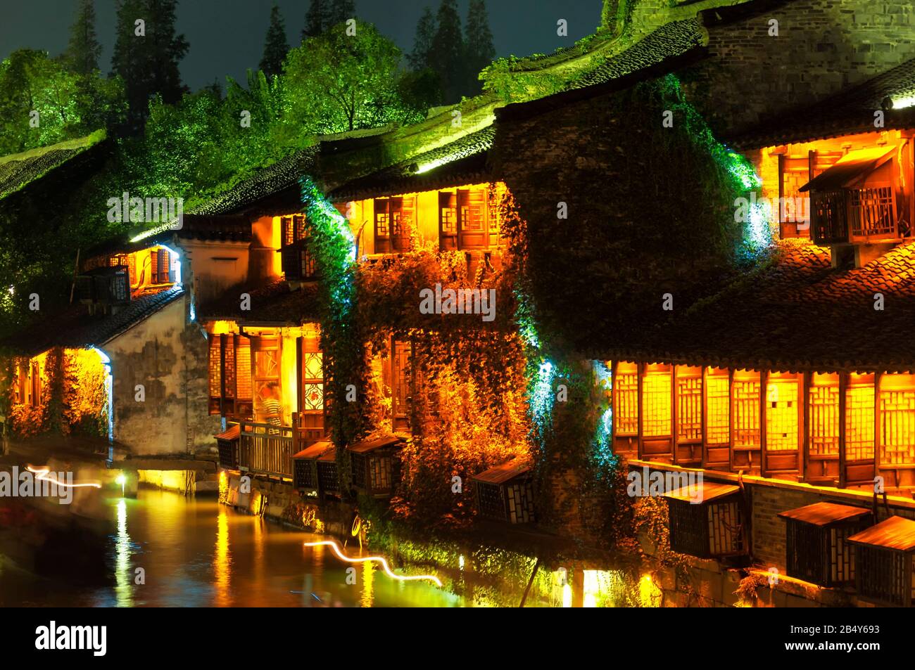 Die beleuchteten Gebäuden entlang der Wasserkanäle in Tongxiang Wuzhen malerischen Westblick auf die Stadt in der Provinz Zhejiang China in der Nacht. Stockfoto