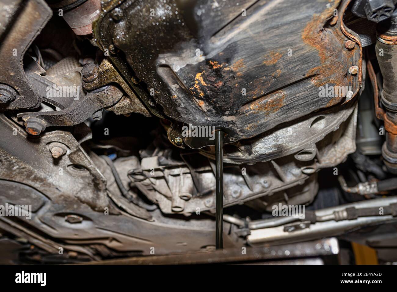 Verbrauchten DieselMotoröl aus einer Ölwanne in einen Metallbehälter in einer KfzWerkstatt