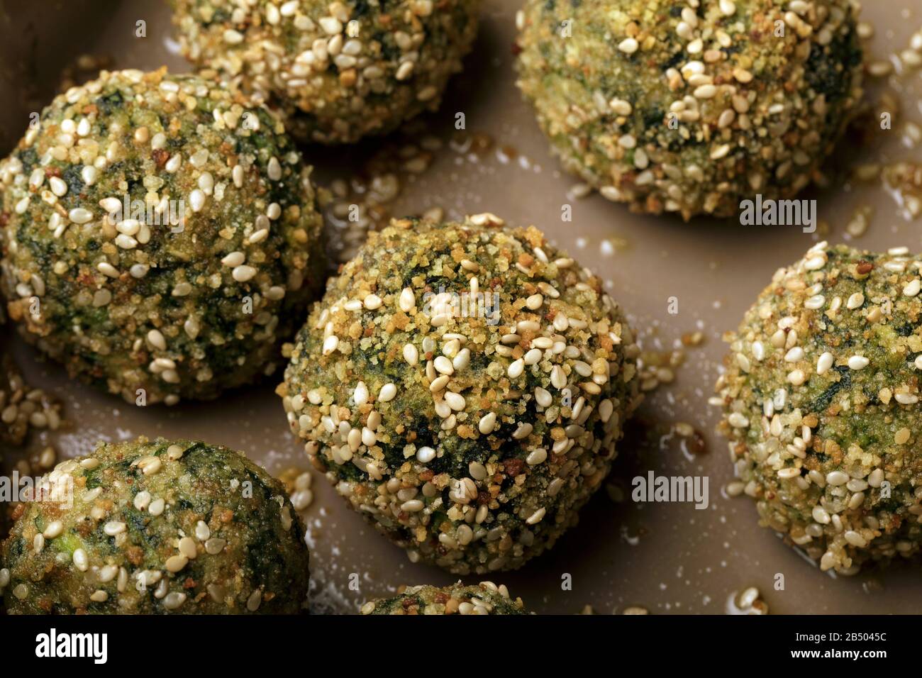 Hacksteaks (Ricotta) und Spinat werden im Ofen mit Brotkrümel und Sesam  zubereitet Stockfotografie - Alamy