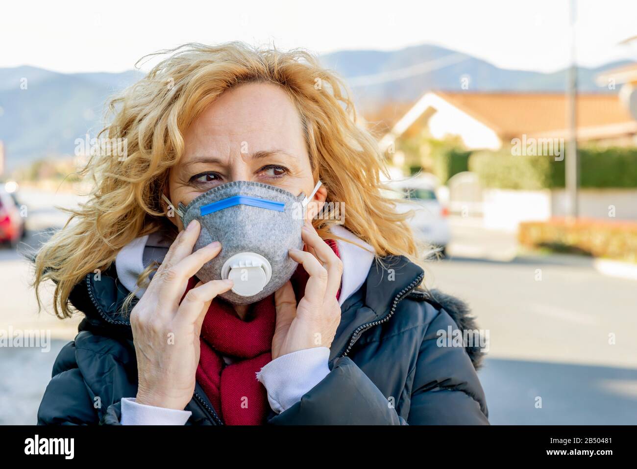 Weiße Frau geht mit der Schutzmaske in den Zeiten des Coronavirus "Covid - 19" auf die Straße, was viele Menschen betrifft Stockfoto