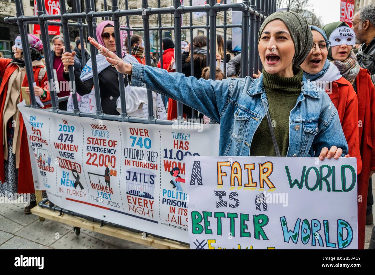 London, Großbritannien. März 2020. Türkische Frauen bringen ein Mock ins Gefängnis, um die Freiheit einer türkischen Journalistin zu fordern, sowie ein Ende der schlechten und unfairen Behandlung von Frauen im Allgemeinen - Millionen Frauen Erheben sich im März, um sich an Frauen und Mädchen zu erinnern, die getötet wurden. Die diesjährigen Themen waren "Nie Vergessen" & "Gerechtigkeit" - "Wir werden nicht zum Schweigen gebracht! Wir werden nicht vergessen!". Die Marscher wurden gebeten, etwas Rotes zu tragen - die Farbe des Blutes, "das Blut unserer Schwestern, die in den Händen männlicher Gewalt ermordet und vergewaltigt wurden." Credit: Guy Bell/Alamy Live News Stockfoto