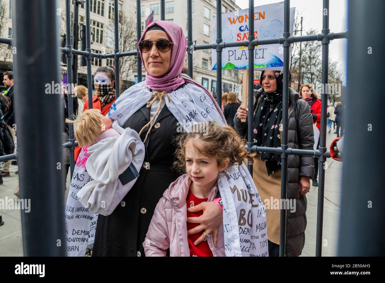 London, Großbritannien. März 2020. Türkische Frauen bringen ein Mock ins Gefängnis, um die Freiheit einer türkischen Journalistin zu fordern, sowie ein Ende der schlechten und unfairen Behandlung von Frauen im Allgemeinen - Millionen Frauen Erheben sich im März, um sich an Frauen und Mädchen zu erinnern, die getötet wurden. Die diesjährigen Themen waren "Nie Vergessen" & "Gerechtigkeit" - "Wir werden nicht zum Schweigen gebracht! Wir werden nicht vergessen!". Die Marscher wurden gebeten, etwas Rotes zu tragen - die Farbe des Blutes, "das Blut unserer Schwestern, die in den Händen männlicher Gewalt ermordet und vergewaltigt wurden." Credit: Guy Bell/Alamy Live News Stockfoto
