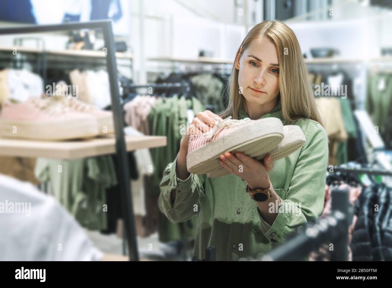 Frau, die im Bekleidungsgeschäft nach neuen Schuhen sucht Stockfoto