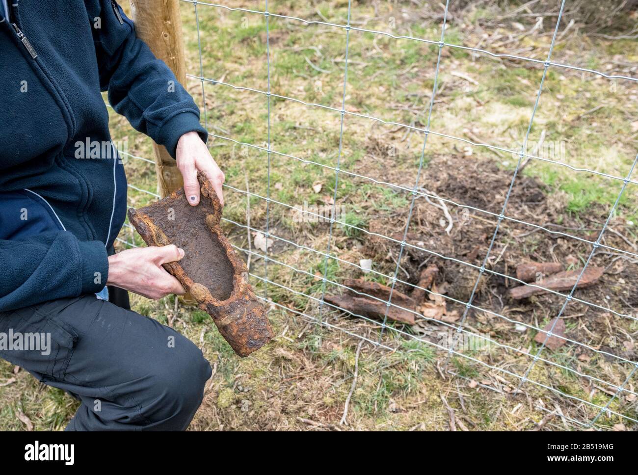 Mann, der eine explodierte Tankschale rund hält. Stockfoto