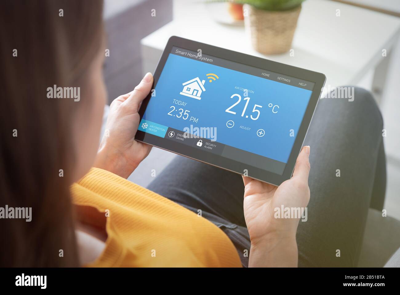 Frau mit Smart Home Application auf Tablet. Smart Home System Konzept Stockfoto