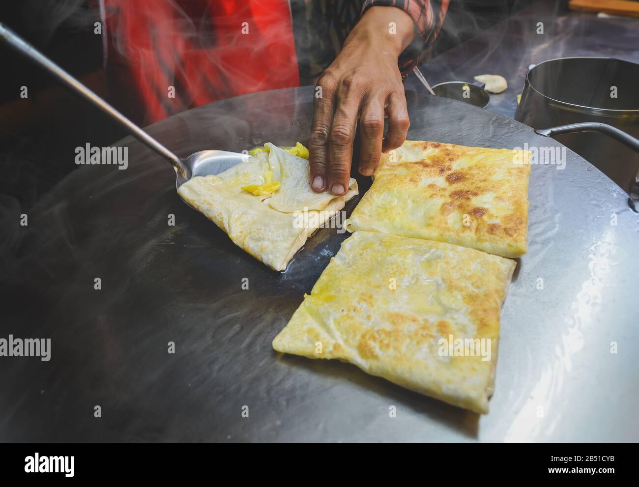 Indische Straßennahrung roti süßer Snack auf dem eisernen Teller mit Nachtbeleuchtung. Stockfoto