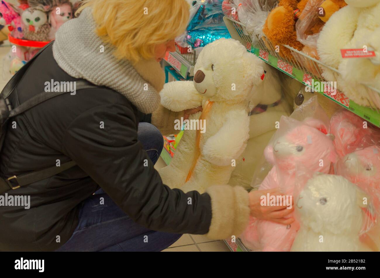 Blondes Mädchen in einem Spielzeug- und Bekleidungsgeschäft. Stockfoto
