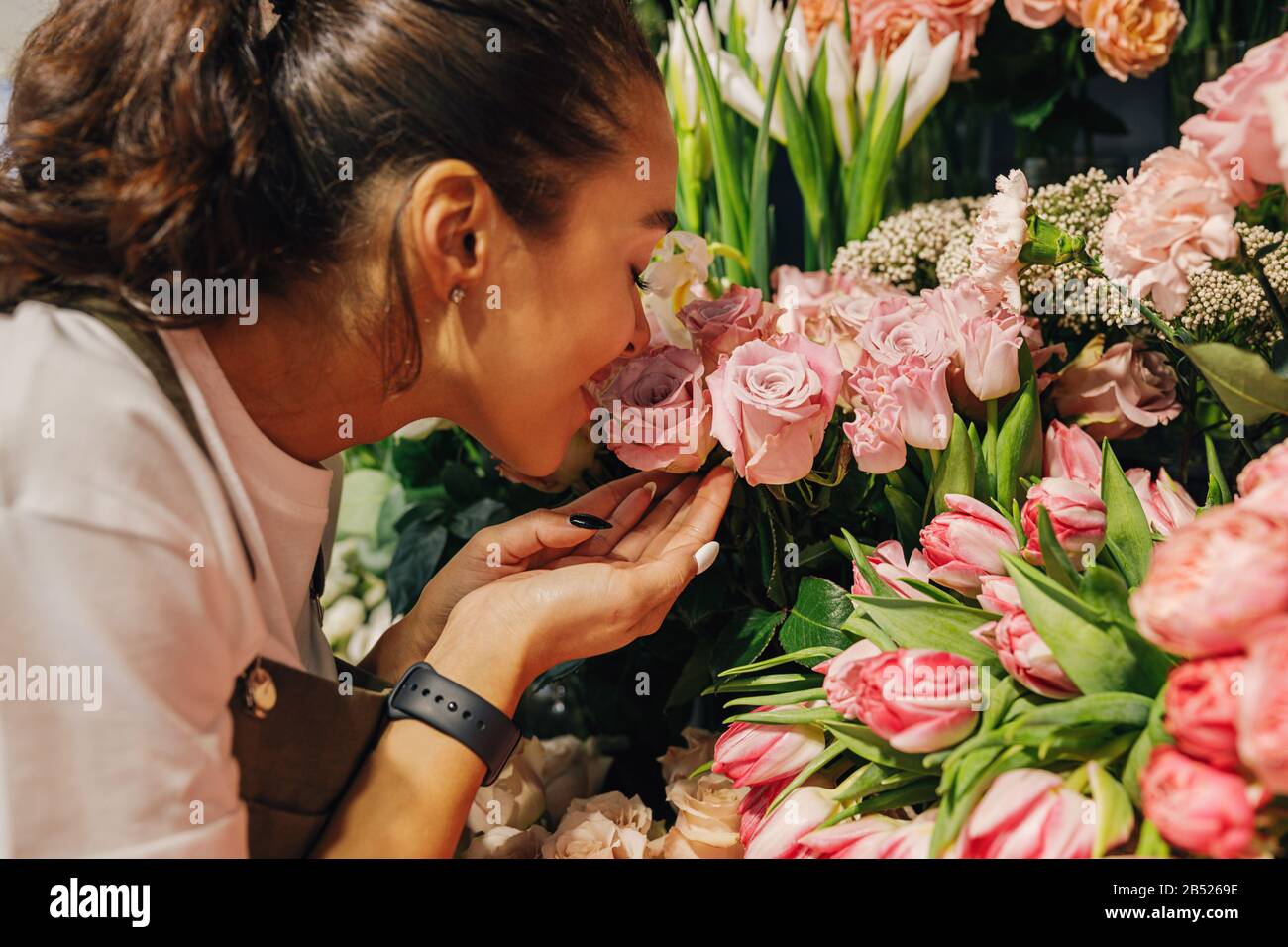Nahaufnahme einer Frau, die die Blumen im Blumenladen riecht. Stockfoto