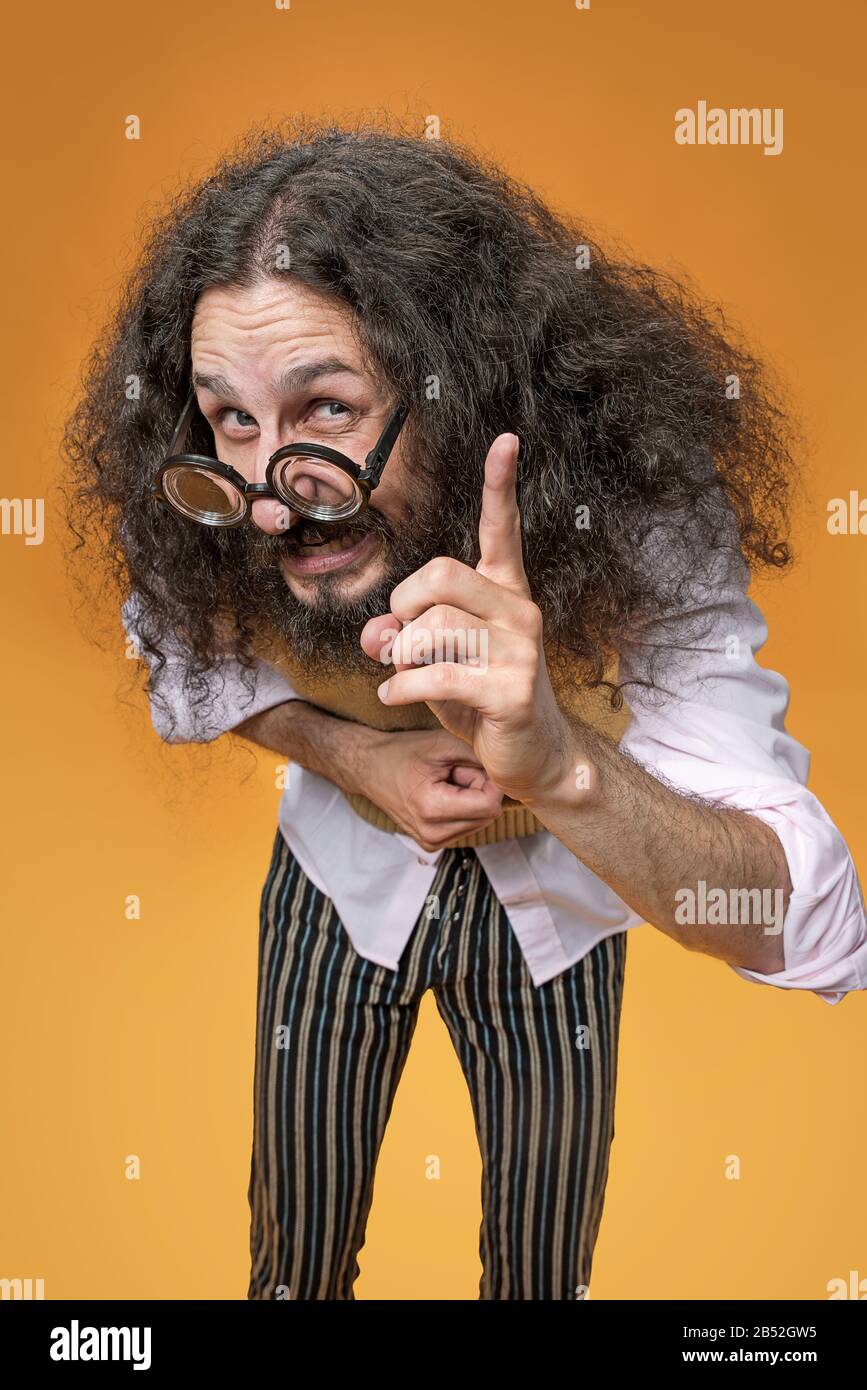 Porträt eines lustigen Geeks, der eine zeigende Geste macht Stockfoto
