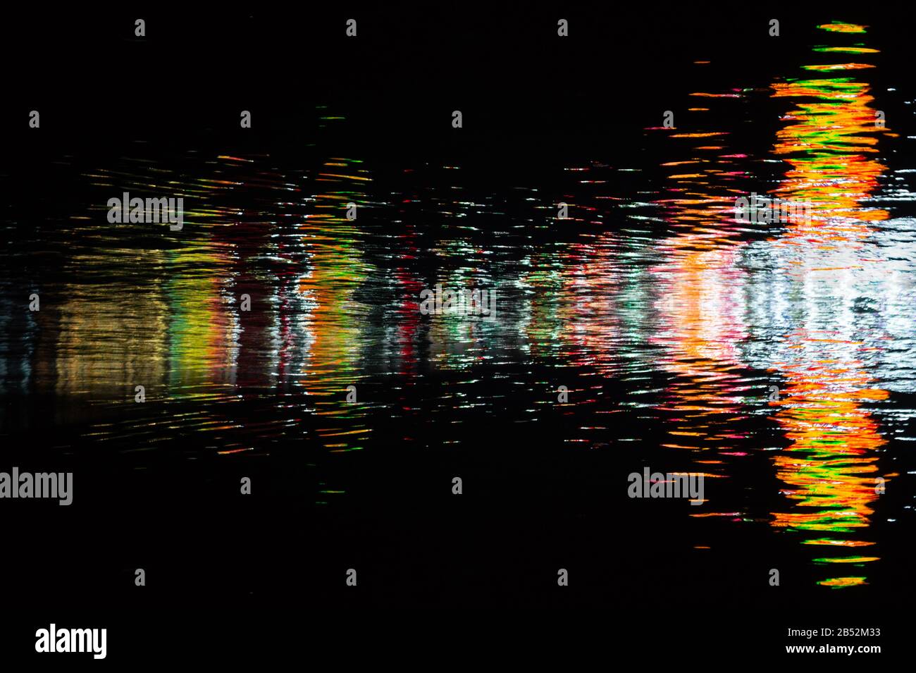 Wassertextur mit Farbreflexionen auf schwarzem Hintergrund Stockfoto