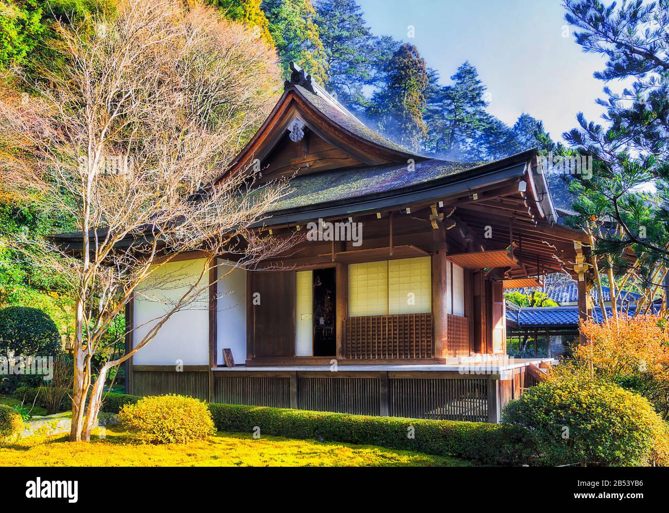 Verdunstungsnebel nach nächtlichem Regen in warmem Morgenlicht vom Holzdach des historischen antiken Tempels im japanischen Ohara-Dorf. Stockfoto