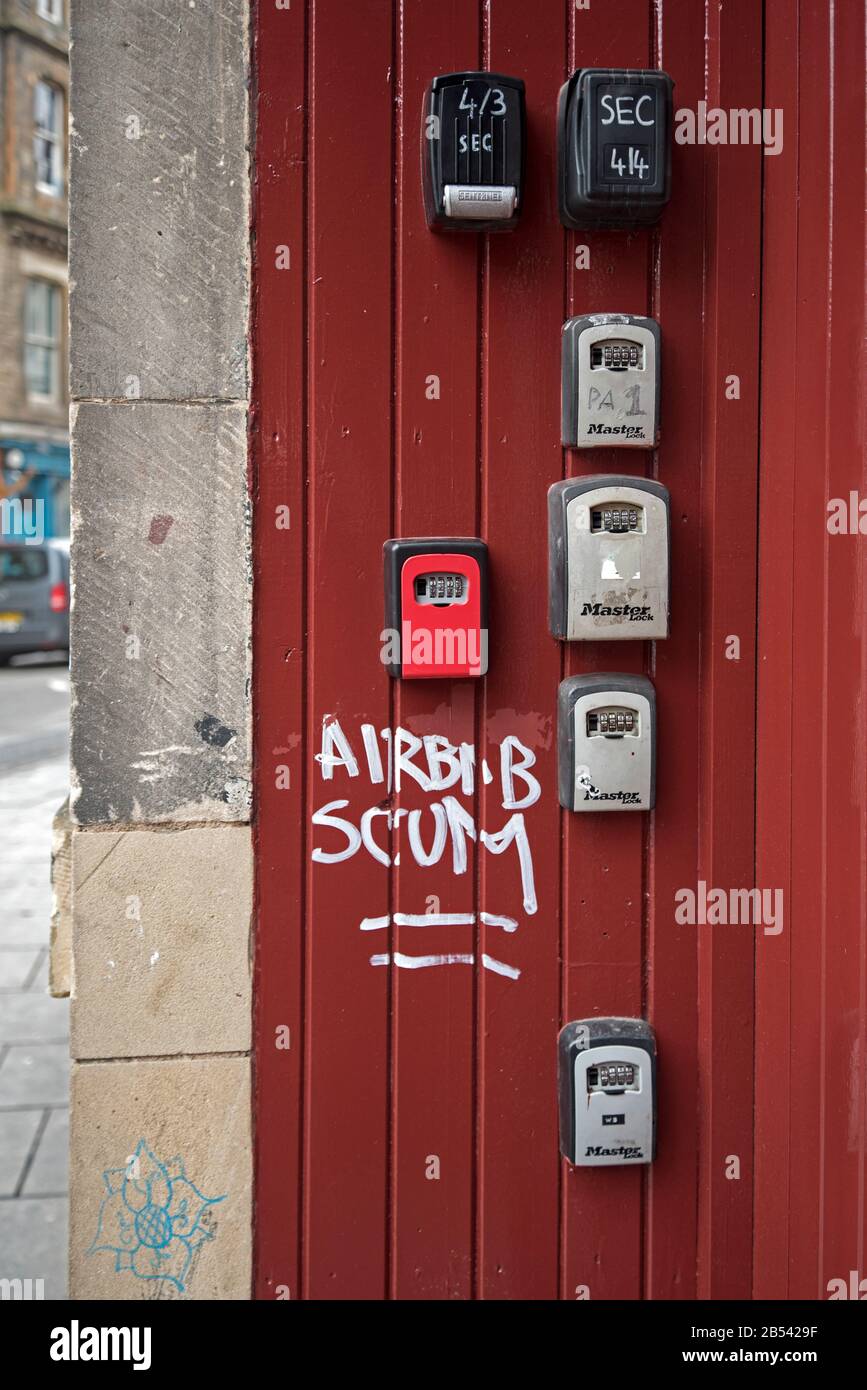 Anti-Airbnb-Graffiti neben Schlüsselsafes für Airbnb oder kurzfristig an der Tür eines Miets in Cowgate, Edinburgh, Schottland, Großbritannien. Stockfoto