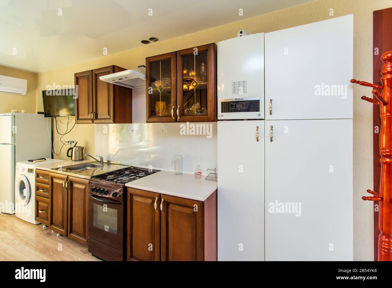 Küche im Gasthaus. Schöne dunkle Holzmöbel. Gaskochfeld mit Abzugshaube.  Kühlschrank Stockfotografie - Alamy