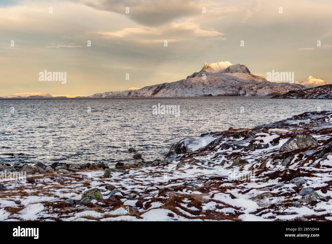 Tiefgefrorene Tundralandschaft mit kaltem grönländischen Meer und schneebeeten Sermitsiaq-Bergen im Hintergrund, nahe der Stadt Nuuk, Grönland Stockfoto