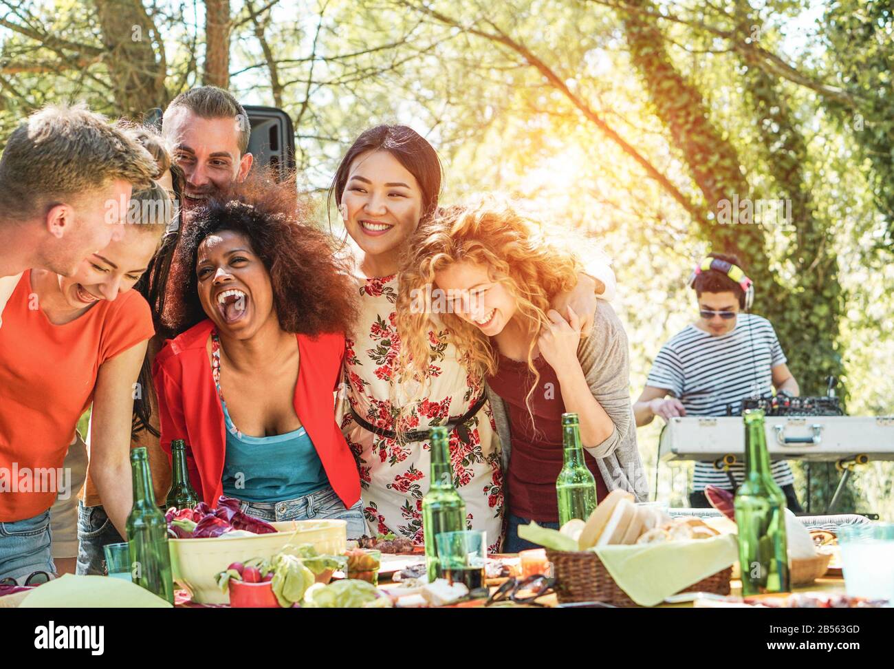 Gruppe junger Leute, die ein Barbecue-Party-Musikfestival in der Natur haben - Fröhliche Freunde lachen und trinken Bier bei einem escusiven Event mit dj-Set-Mixing Stockfoto