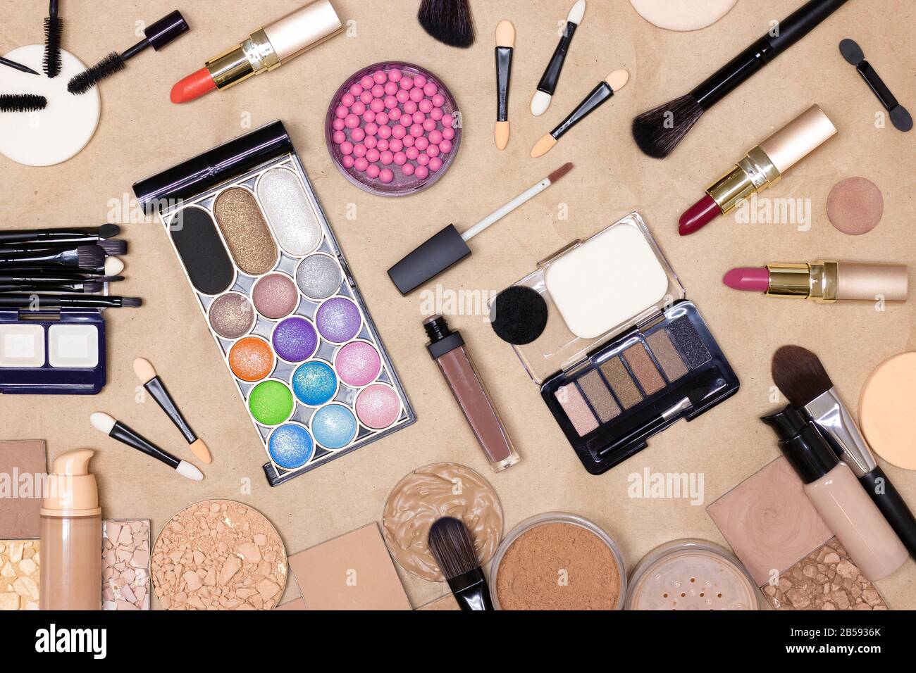 Make-up-Produkte und Zubehör auf Kraftpapier. Make-up-Tisch. Draufsicht, flacher Lay Stockfoto