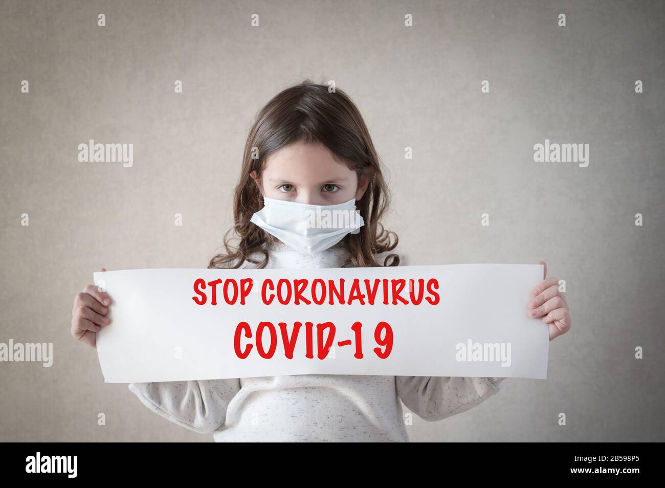 Health Care Covid 19 Epidemie Ausbruch Konzept des kleinen Mädchens in medizinischer Maske mit Papierbanner mit Slogan STOP coronavirus Stockfoto