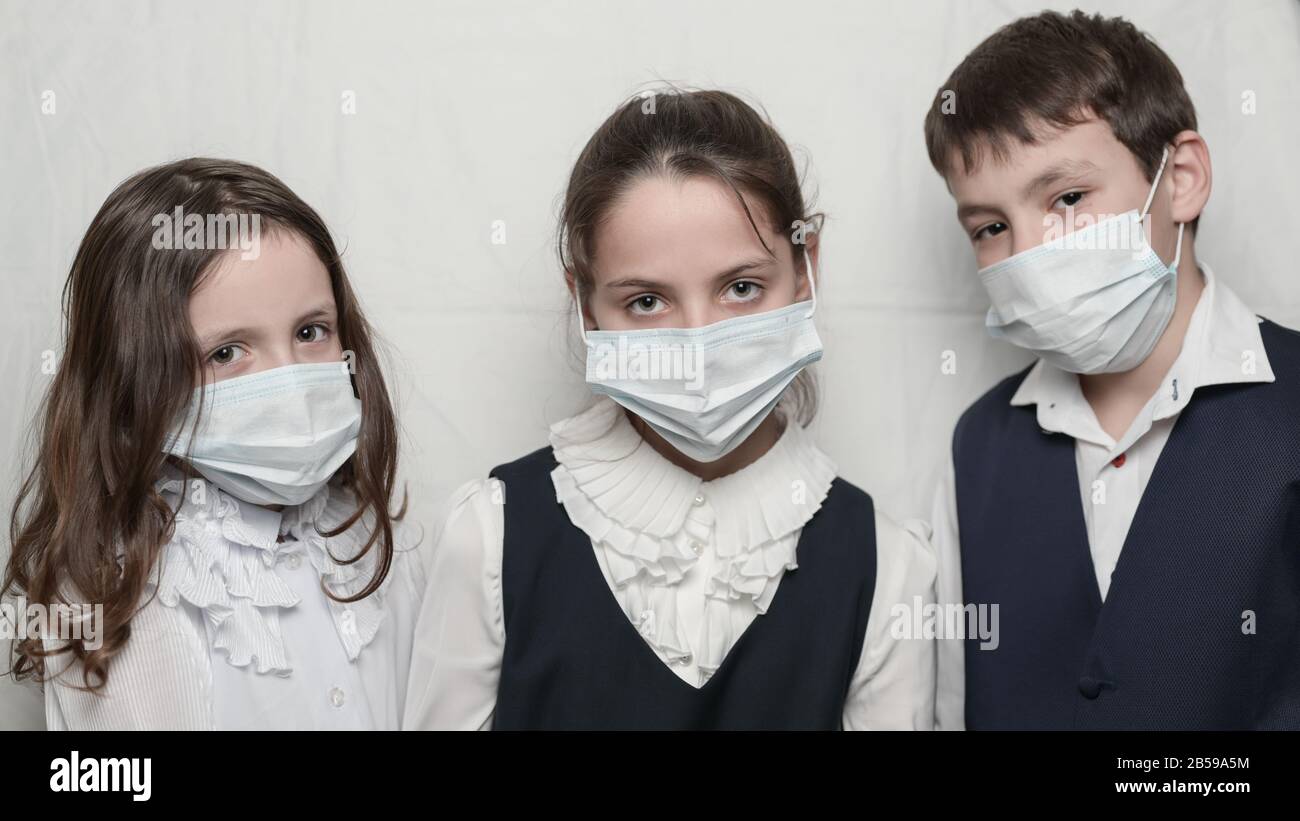 Coronavirus Kovid 19 Epidemie Ausbruch Gesundheitskonzept der Familie Kinder in der Schuluniform tragen medizinische Masken Stockfoto