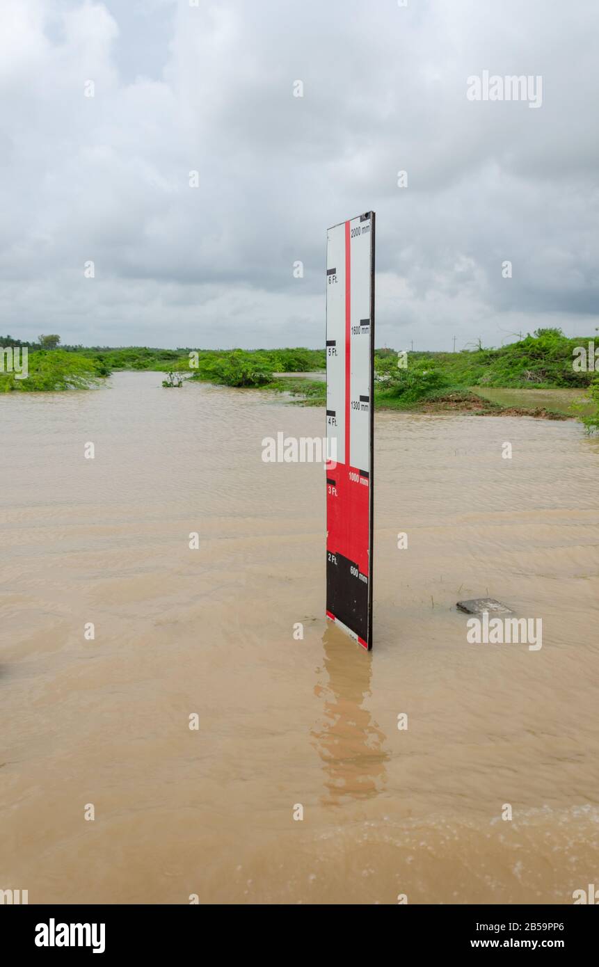 Der Wasserspiegel am Straßenrand zeigt die Wassertiefe des Hochwassers bei starken Regenfällen in Mandvi, Kutch, Gujarat, Indien Stockfoto