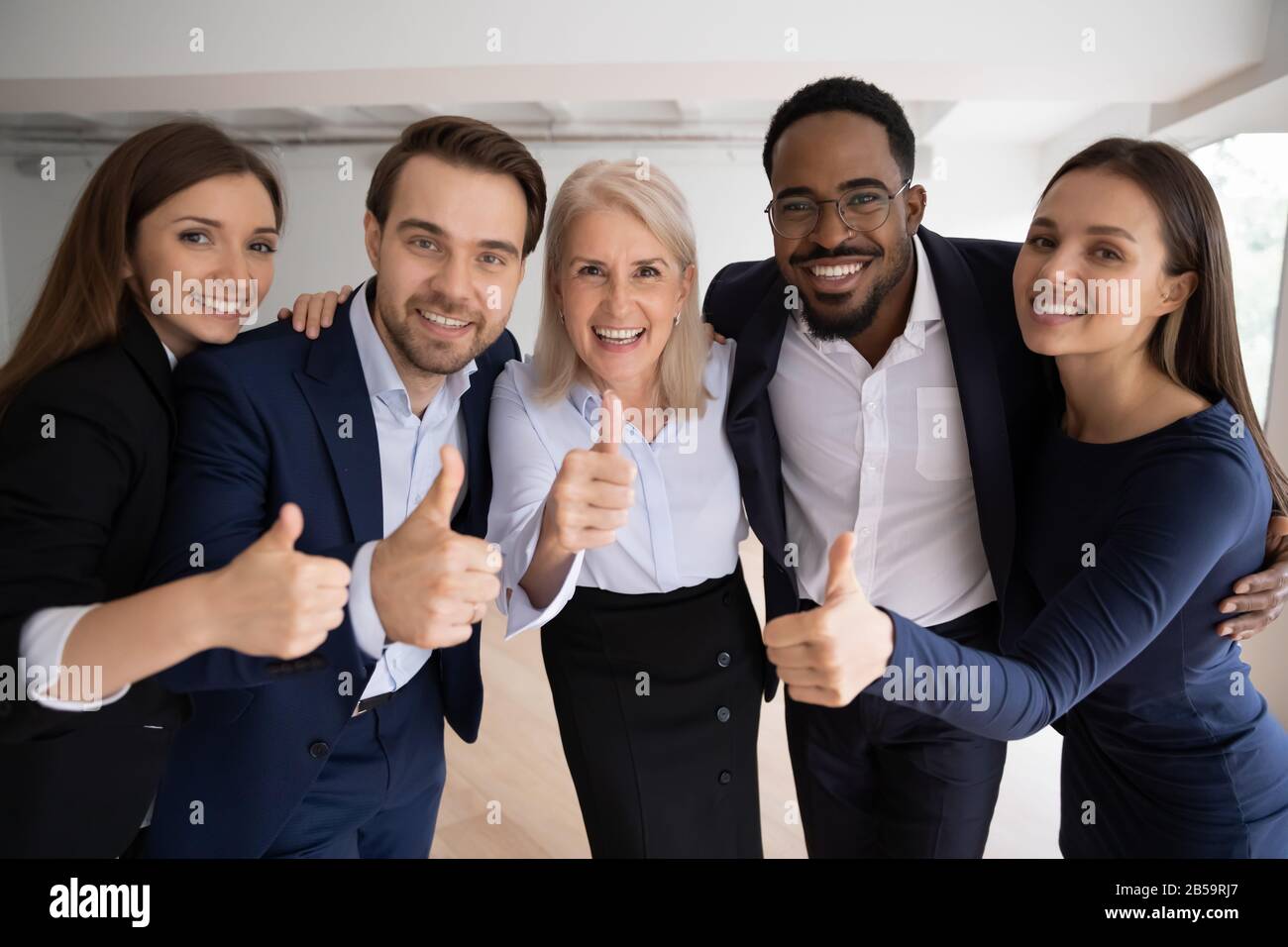 Lächelnde Mitarbeiter mit mehreren Rassen zeigen, dass sie den Service empfehlen Stockfoto