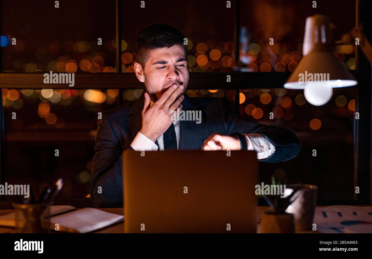 Geschäftsmann Gähnelt Prüfzeit Spät In Der Nacht Im Büro Stockfoto